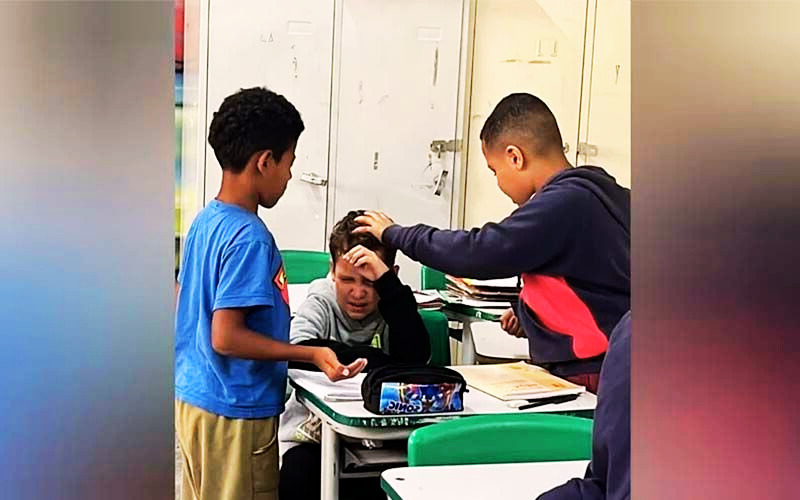 DOS ESTUDIANTES ORAN POR SU COMPAÑERO ENFERMO EN PLENA CLASE